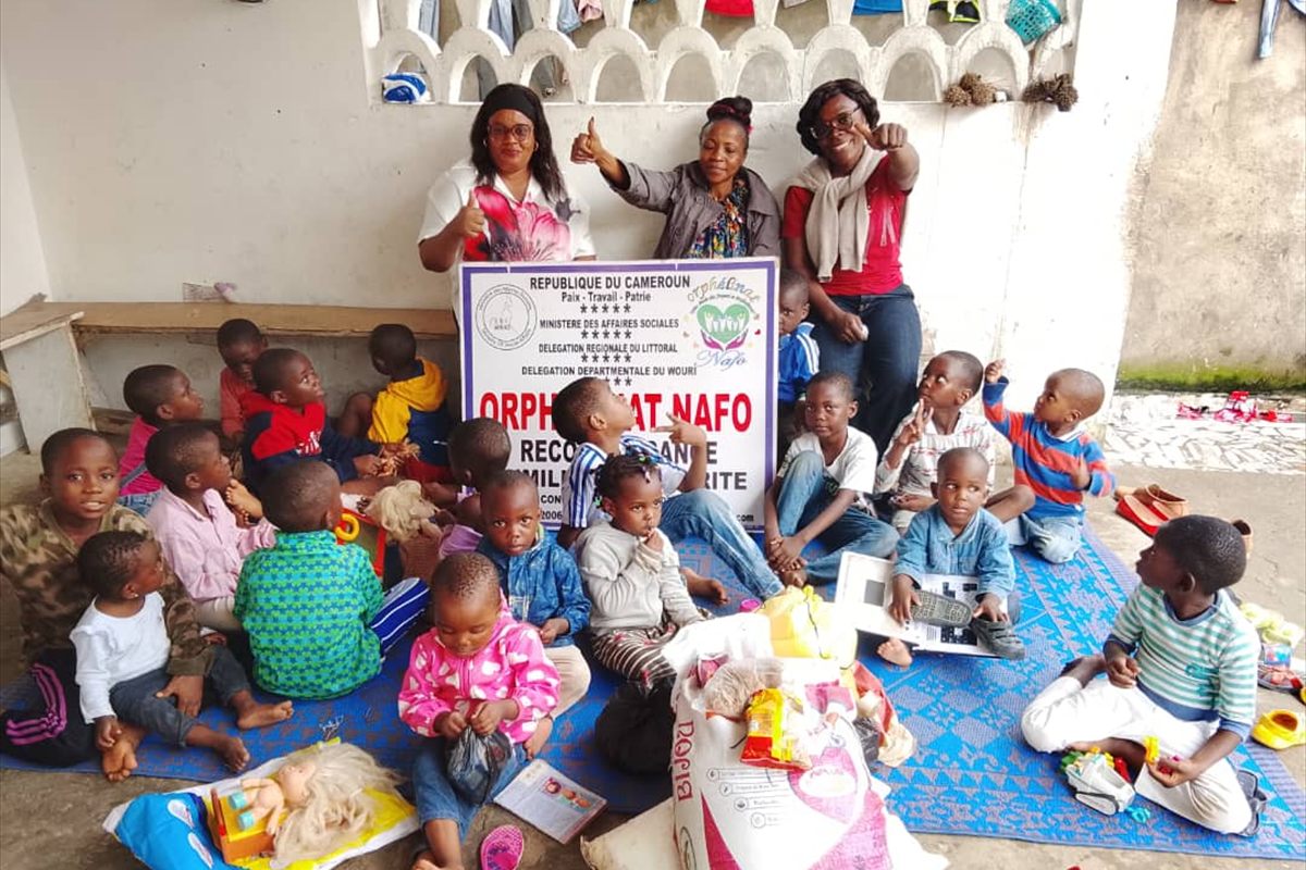 La remise des dons à l’orphelinat : l’équipe et les enfants réunis.